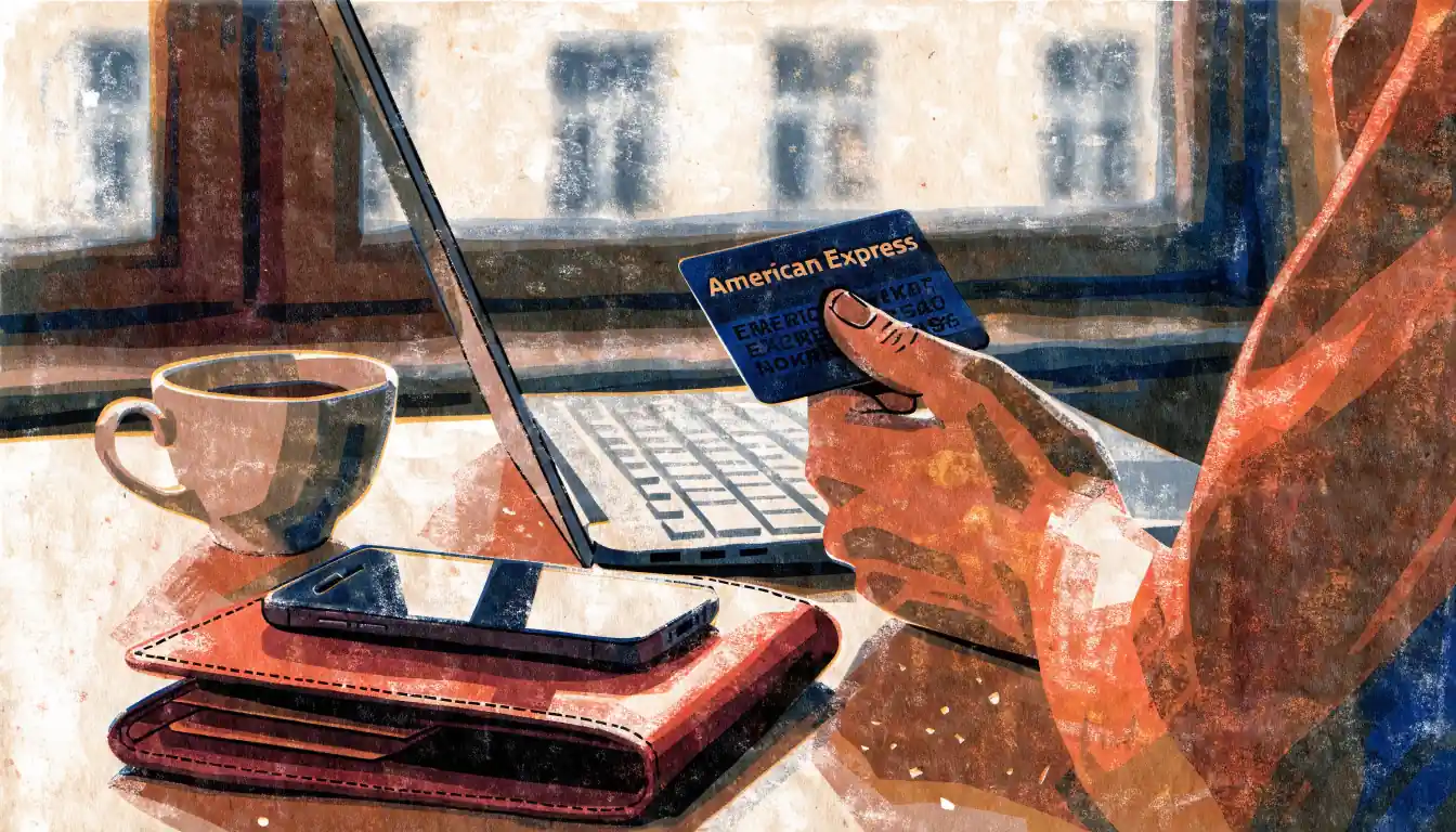 American-Express-Karte neben Laptop auf Schreibtisch in warmer Abendbeleuchtung